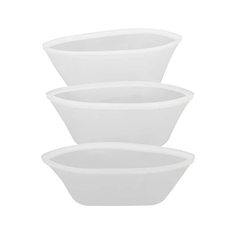 Set of three white reusable silicone food storage bags in varying sizes.