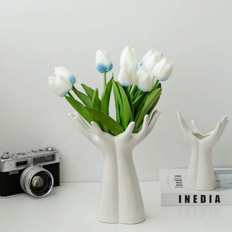 Modern ceramic vase shaped like hands holding a flower bouquet, ideal for tabletop decoration.