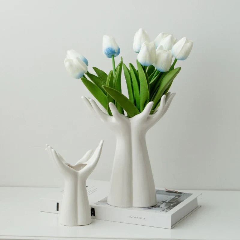 Ceramic vase shaped like hands holding a bouquet, modern porcelain home decoration.