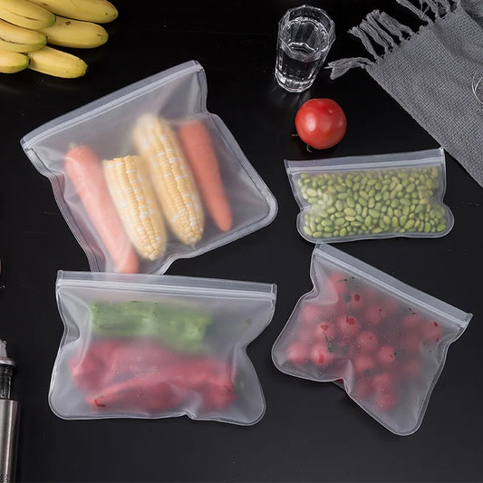 Set of reusable silicone food storage bags with zip seal containing vegetables and fruits on black surface