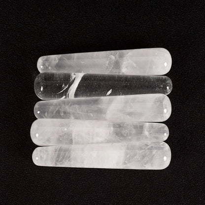 Natural rose quartz crystal face massager sticks on black background.