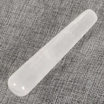 Natural rose quartz crystal face massager on a woven fabric background.