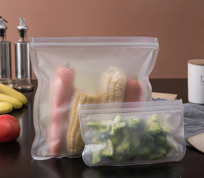 Reusable silicone food storage bags with zip seal containing vegetables and corn on kitchen counter