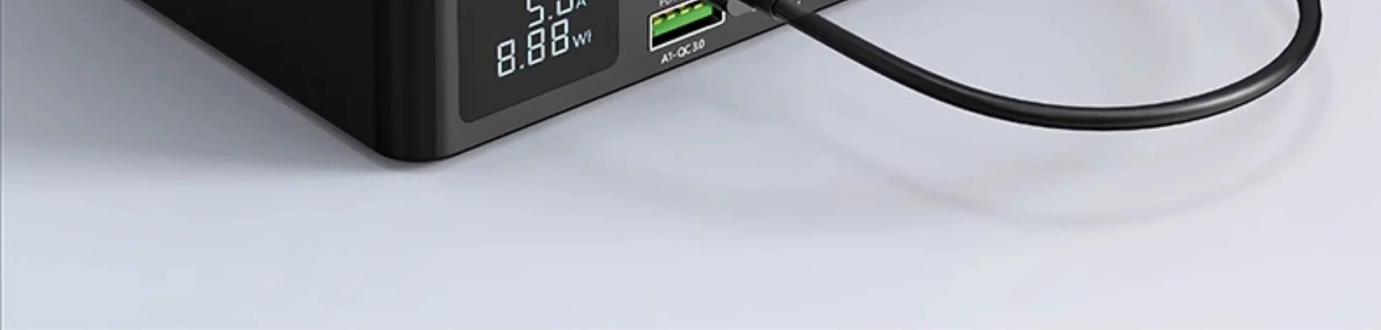 GaN fast charger with USB and Type-C ports, digital display showing power output, black design.