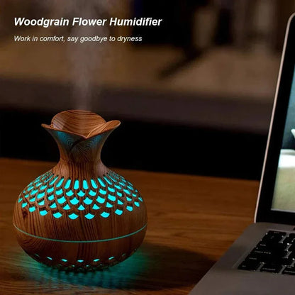 Wood grain humidifier with colorful lights on a desktop next to a laptop.