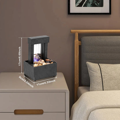Mini tabletop fountain with light on bedside table for relaxation and Zen meditation.