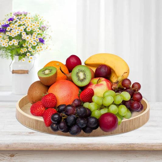 Wooden serving tray with assorted fruits in a home setting.