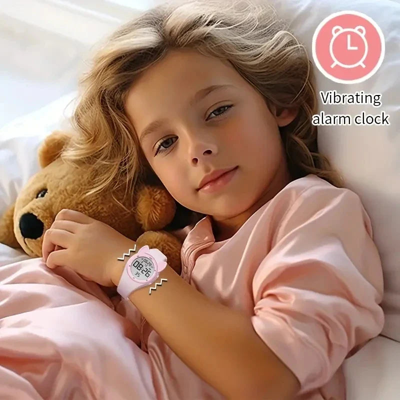 Kids fitness tracker watch with vibrating alarm clock, worn by a child resting with a teddy bear.