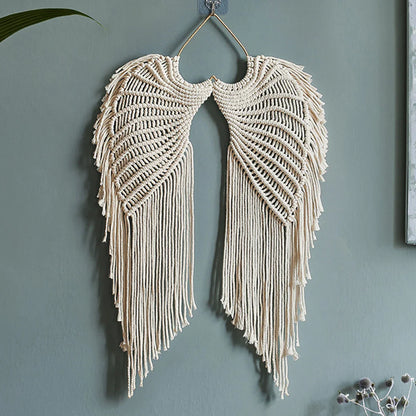 Macrame wall hanging tapestry with angel wing design in beige, handmade woven art decor for living room or bedroom.