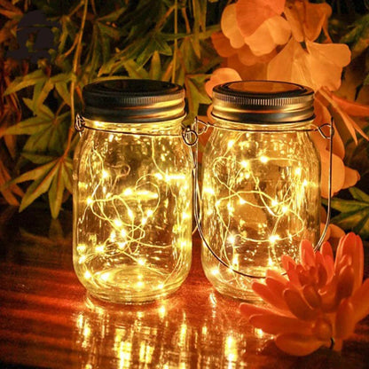 Solar mason jar lights illuminated on a table, enhancing outdoor decor with warm white LED ambience.