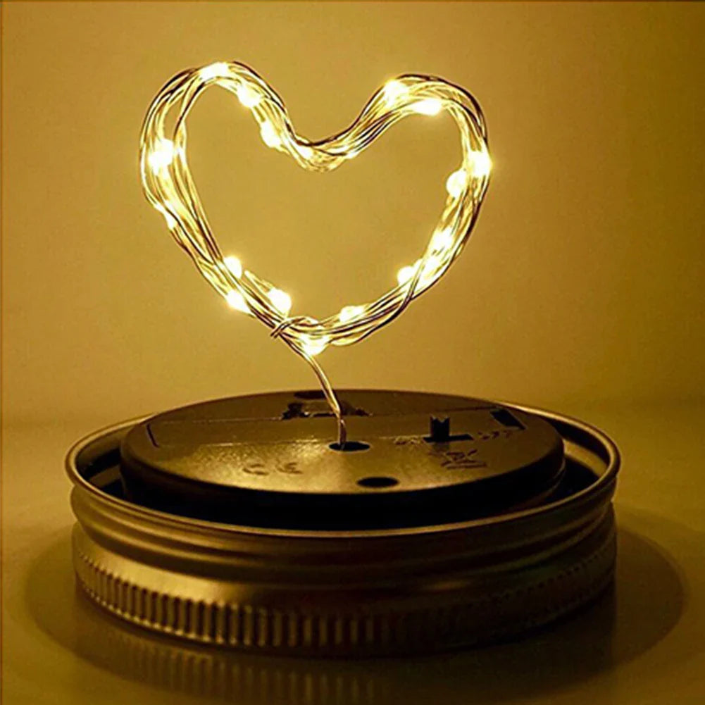 Heart-shaped solar mason jar light with warm white LEDs for garden decor.