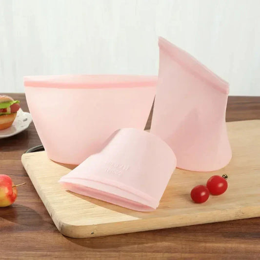3-piece set of reusable silicone food storage bags on a kitchen counter.