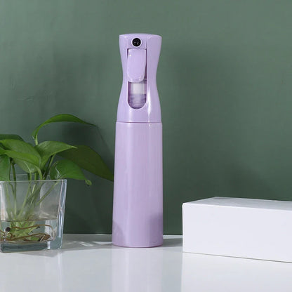 Purple high pressure spray bottle, 300ml, for skincare and nail care, next to a plant and a box.