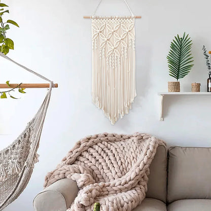 Handmade beige macrame wall hanging tapestry with tassels, ethnic woven art for home decor in living room or bedroom.