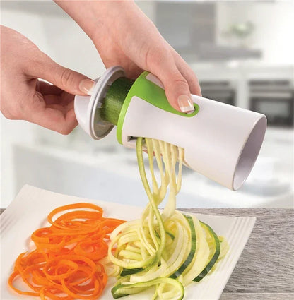 Vegetable spiralizer creating zucchini noodles with stainless steel blades in a kitchen setting.