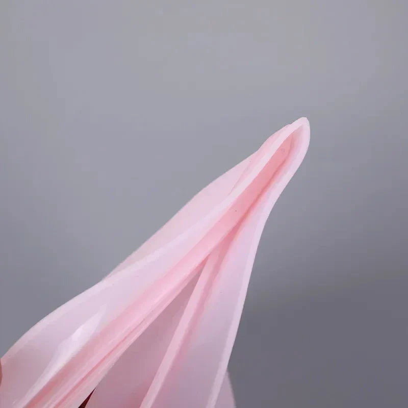 Reusable silicone food storage bag in soft pink color held open for display.
