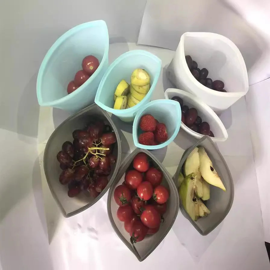 Reusable silicone food storage bags with various fruits displayed inside.