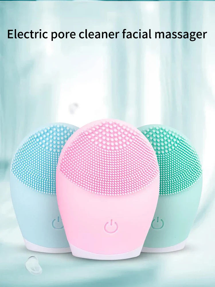 Electric facial cleansing brush in pink, blue, and green silicone with vibration massage feature.