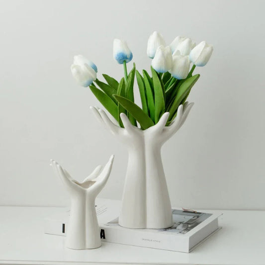 Ceramic vase shaped like hands holding a bouquet, modern porcelain home decoration.