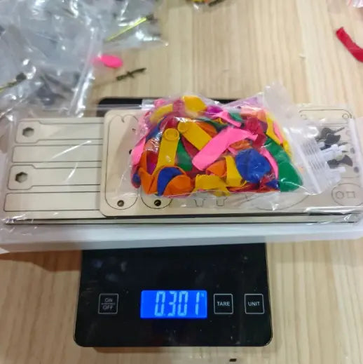 Interactive wooden figurines toy parts on digital scale showing 0.301 weight