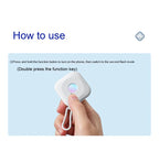 Hand holding smart mini camera detector with a finger pressing the function button against a light blue background with usage instructions.