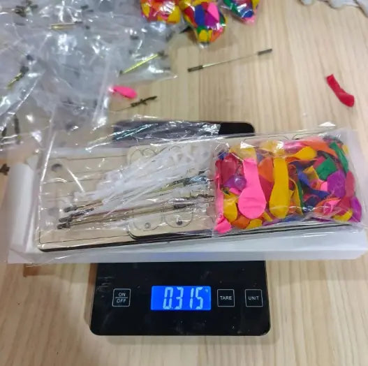 Interactive wooden figurines with colorful movable parts on a digital scale showing weight of 0.315 kg